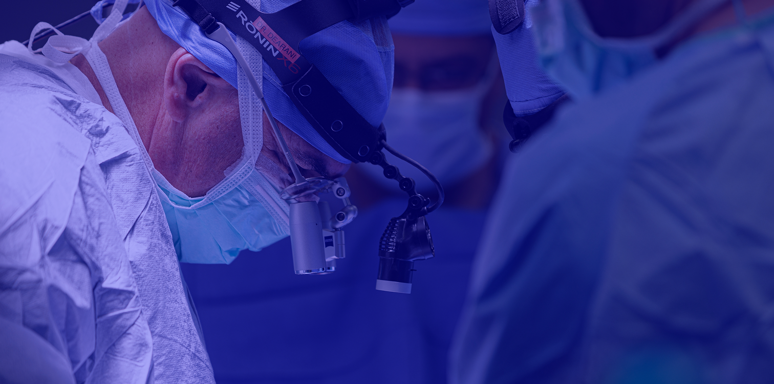 Surgeon with a mask and glasses looking down during surgery