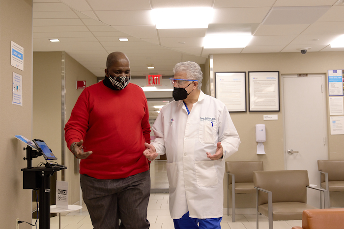 Dr. Lattouf talks with a patient as they walk down the hallway.