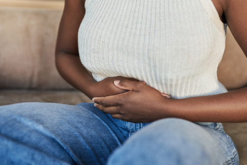 Woman sitting in chair with hands in lap.