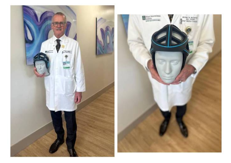 Neurosurgeon Michael McDermott, M.D., holds the prototype for a surfing helmet that he designed.